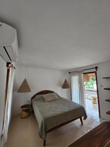 a bedroom with a bed and a sliding glass door at Pangaro House in Katiet