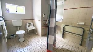 a small bathroom with a toilet and a shower at Higgins Lane Motel in Margaret River Town +15 photos