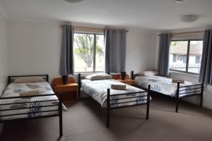 a bedroom with two beds and a window at San Michele Adaminaby in Adaminaby