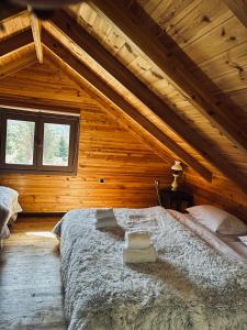 a bedroom with a large bed in a wooden house at The Farmhouse in Vitina