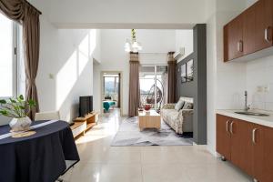 a kitchen and a living room with a table at Yalong Sea Joy in Sanya