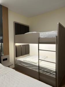 a bedroom with two bunk beds with white sheets at Serenity Homestay Penuin Batam in Batam Center