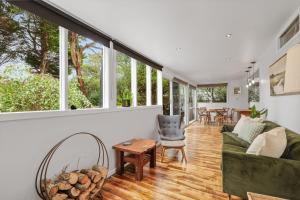 a living room with windows and a couch and a table at The Bach at Ventnor in Ventnor