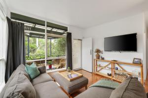 a living room with a couch and a large window at The Bach at Ventnor in Ventnor