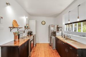 a kitchen with white walls and a wooden floor at The Bach at Ventnor in Ventnor +12 photos