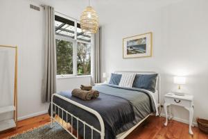 a bedroom with a bed with a teddy bear on it at The Bach at Ventnor in Ventnor