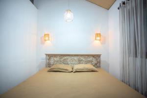 a bedroom with a bed with two pillows on it at Nasha Lanka House in Koggala