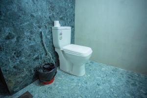 a bathroom with a toilet and a trash can at Nasha Lanka House in Koggala +17 photos