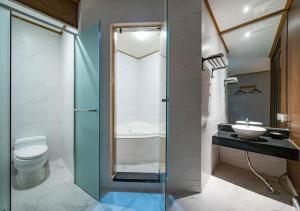 a bathroom with a shower and a toilet and a sink at Nabeeya Hotel in Siheung +33 photos