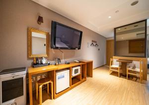 a living room with a television on the wall at Nabeeya Hotel in Siheung