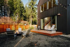 a house with a deck with chairs and a table at Camp Alpine in Packwood