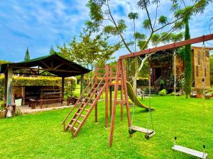 a wooden playground with a slide in a yard at Cabañas ecológicas Xuetama in Villa de Leyva