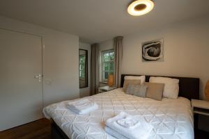 a bedroom with a bed with towels on it at Unique tranquil spot with garden, centre Den Bosch in Den Bosch