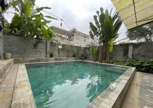 a swimming pool with turquoise water in a backyard at Brotherhood Loop Hostel Station in Làng Lap