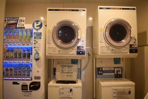 a room with two washing machines and other machines at Sun Hotel Kudamatsu in Hanaoka