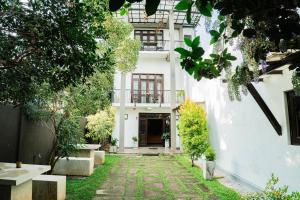 a white building with a walkway in front of it at Walker's Residency in Anuradhapura +15 photos