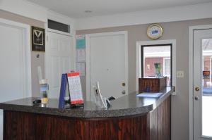 an office with a counter and a clock on the wall at Merrimac Inn and Suite in Williamsburg