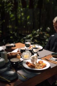 a table with plates of food and glasses of wine at Kaya Retreat in Diyatalawa