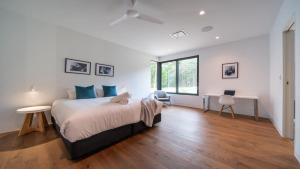 a bedroom with a bed and a desk and a window at Launa Killcare Heights in Killcare