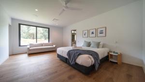 a bedroom with a large bed and a window at Launa Killcare Heights in Killcare