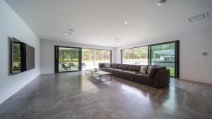 a large living room with a couch and large windows at Launa Killcare Heights in Killcare +13 photos