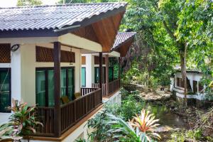 a house with a pond in front of it at Bidaisari Resort in Kampong Sum Sum