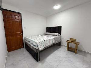 a bedroom with a bed and a wooden door at Posada Del Puerto in Armenia