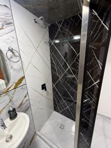 a shower with a glass door next to a sink at Posada Del Puerto in Armenia