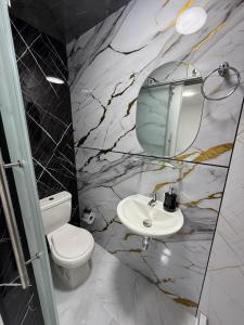 a bathroom with a toilet and a sink and a mirror at Posada Del Puerto in Armenia