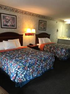 a hotel room with two beds and two lamps at Merrimac Inn and Suite in Williamsburg +9 photos