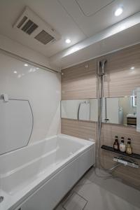 a bathroom with a bath tub and a shower at Apartment Hotel 11 Shinsekai in Osaka +22 photos