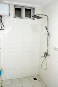 a shower in a white tiled bathroom at Beach Sand Hotel & Resort, Cotonou in Cotonou +53 photos