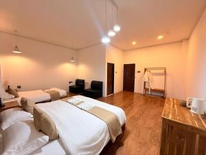 a hotel room with two beds and a chair at Sunin Hotel Dondet Riverside in Don Det