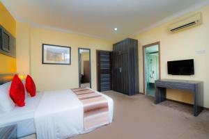 a bedroom with a bed and a desk and a television at HIG Hotel & Convention in Kuah +33 photos