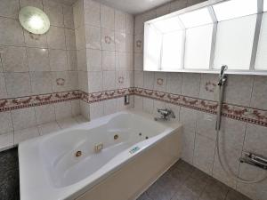 a white bath tub in a bathroom with a window at ホテルラフィネ in Toyonaka +18 photos