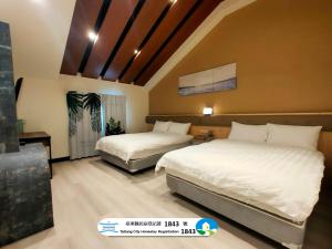 a bedroom with two beds and a tv in it at 山淺民宿 Yamasaki Old House in T'ai-pin-ts'un