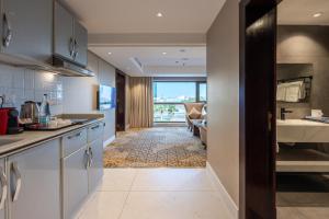 a kitchen with a view of a living room at Quiet Dreams - Serviced Apartments King abdul Aziz Street Branch in Jeddah