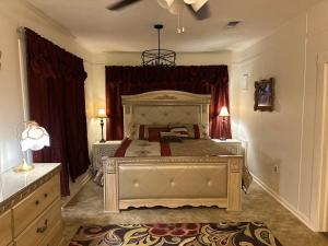 a large bedroom with a large bed with red curtains at The Cleveland Cottage in Brookhaven