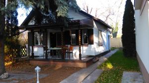 a small white house with a table and chairs at Napsugár Vendégházikó in Orosháza