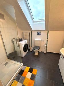a bathroom with a toilet and a sink and a skylight at Über den Dächern Kemptens mit Panoramablick in Kempten +5 photos