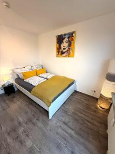 a bedroom with a bed and a painting on the wall at Über den Dächern Kemptens mit Panoramablick in Kempten
