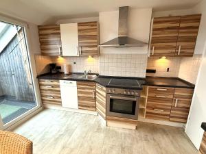 a kitchen with wooden cabinets and a sink at Über den Dächern Kemptens mit Panoramablick in Kempten