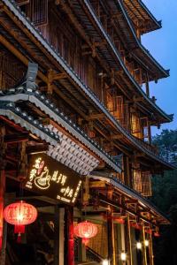 a building with a sign on the side of it at 素隐乡宿Hometown Destination红瑶吊脚楼 观景民宿 in Heping