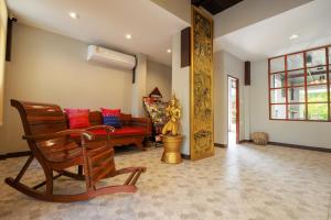 a living room with a bench with red and blue pillows at Cozy Lanna Hotel in Chiang Mai