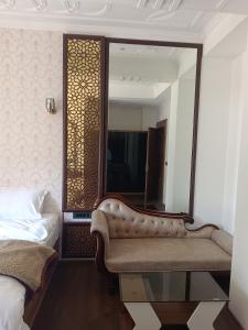 a bedroom with a couch in front of a mirror at Pine Breeze Luxe in Gulmarg +3 photos