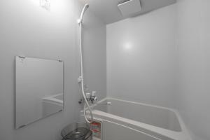 eine Dusche in einem weißen Badezimmer mit Spiegel in der Unterkunft RT2 103 rk in Sapporo