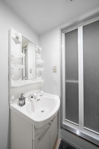 ein weißes Badezimmer mit Waschbecken und Dusche in der Unterkunft RT2 103 rk in Sapporo