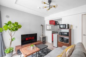 ein Wohnzimmer mit Sofa und Fernseher in der Unterkunft RT2 103 rk in Sapporo