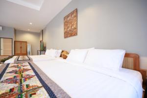 two beds in a hotel room with white sheets at Cozy Lanna Hotel in Chiang Mai +220 photos