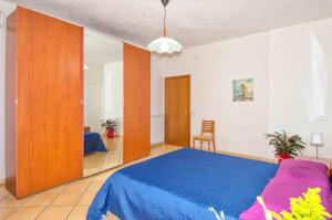 a bedroom with a blue bed and a chair at Casa Granata in Trapani